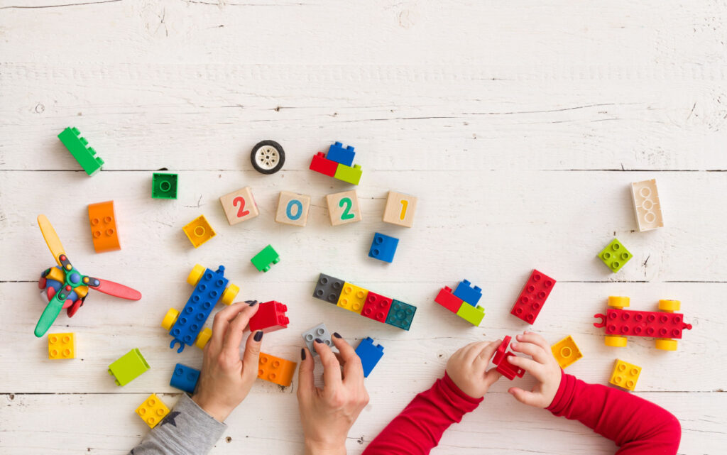 Child and parent playing with duplo and number blocks in an eclectic homeschool. 